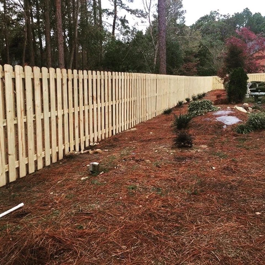 Wood picket fence on slope by MBK Fencing